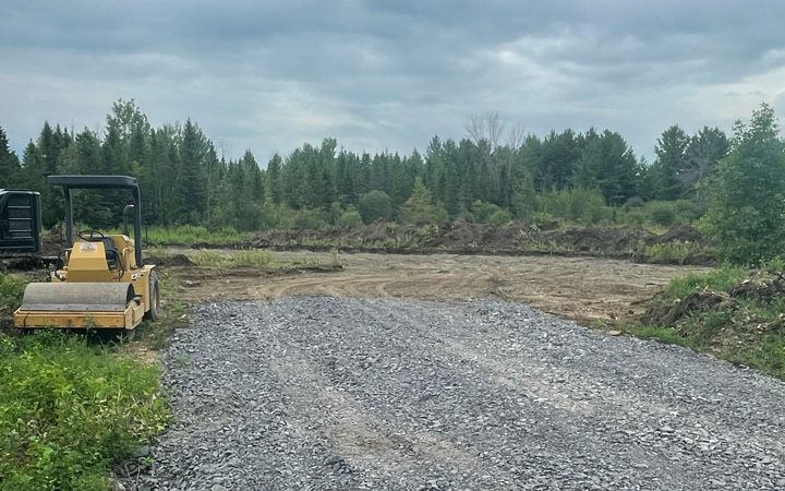 Image of steamroller on excavated land with gravel driveway
