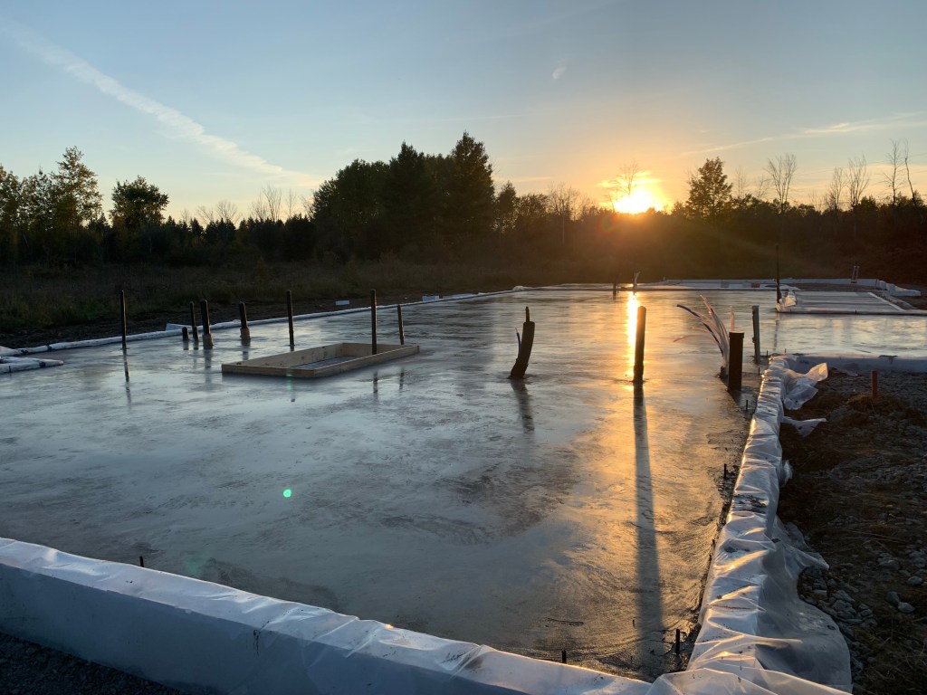 Image of freshly poured concrete slab foundation as sun sets