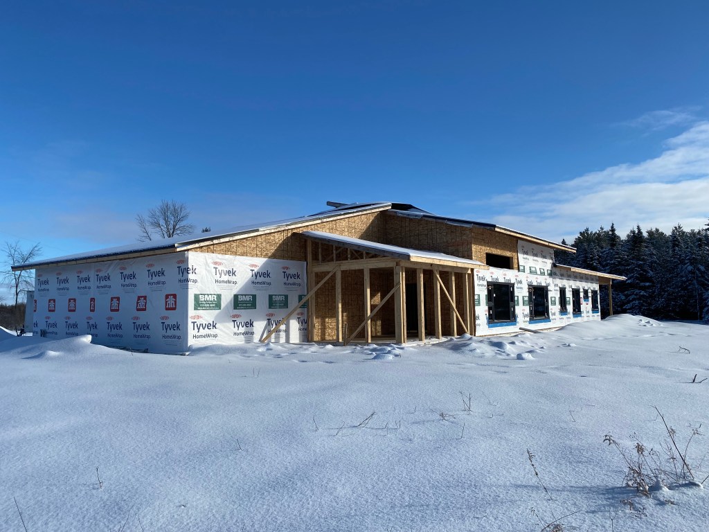 Picture of house under construction with windows installed on south-facing plane