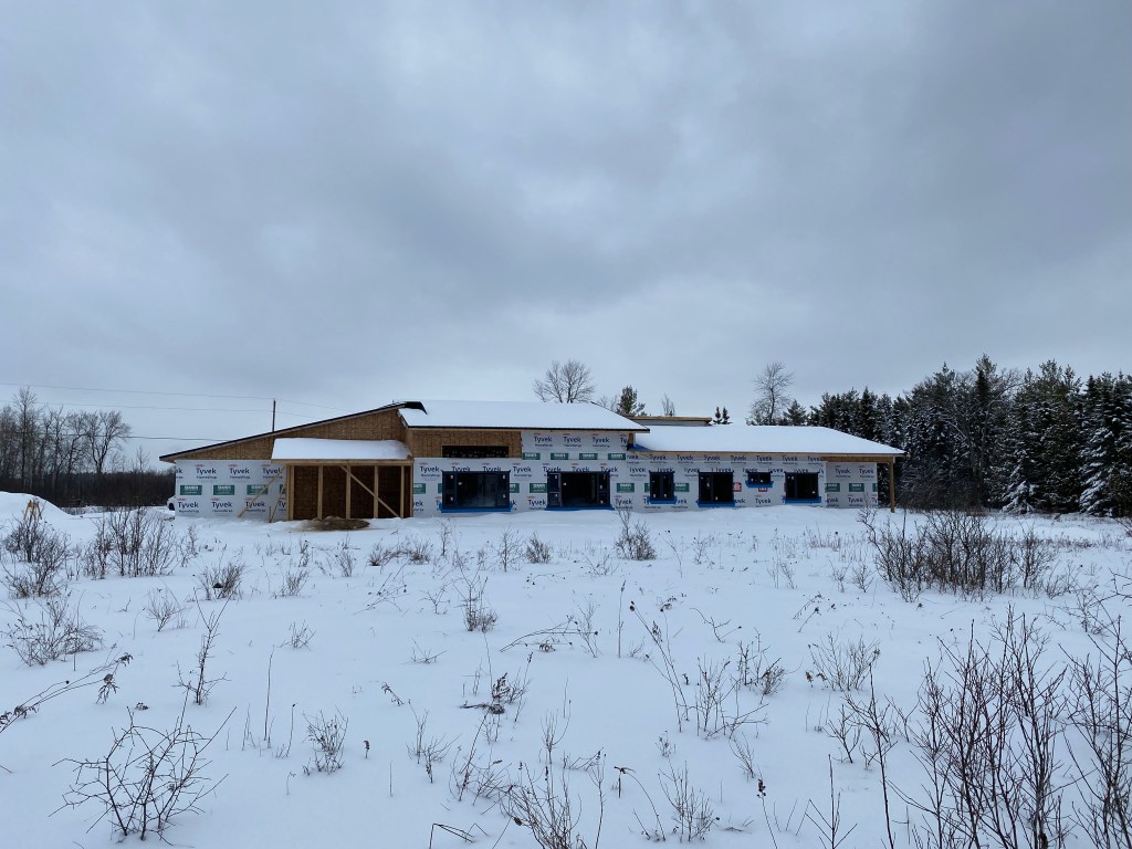 Picture of house under construction with snow on roof
